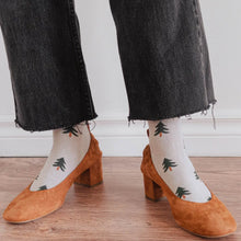 Load image into Gallery viewer, photo of a pair of shoes with a person wearing beige coloured socks and little evergreen trees on them . 
