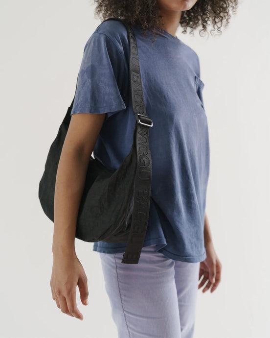 a person carrying a black baggu crescent handbag