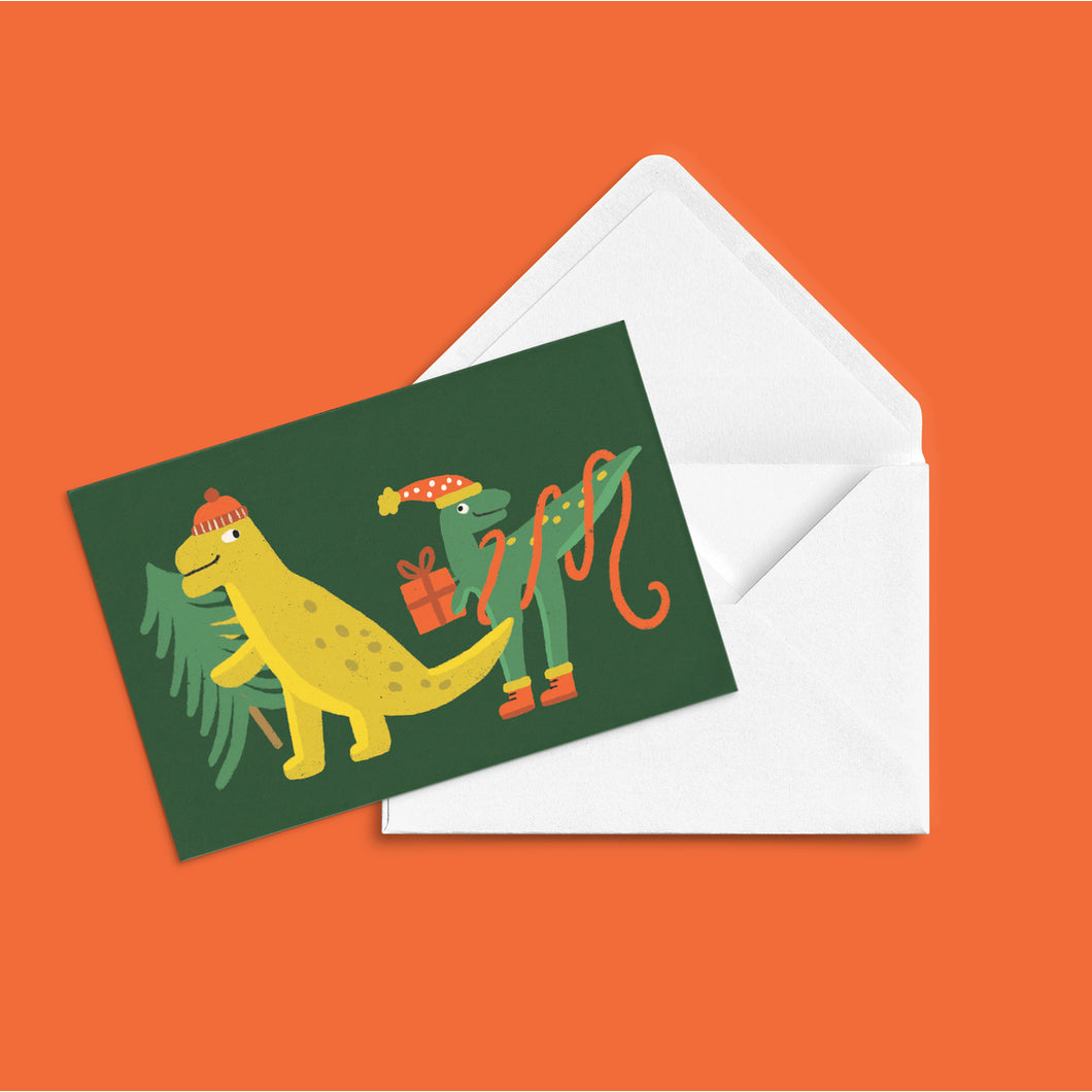 COLOURFUL CGREETING CARD ILLUSTRATION OF TWO DINOSAURS WEATING WINTER HATS AND CARYING GIFTS AND A CHRISTMAS TREE. 