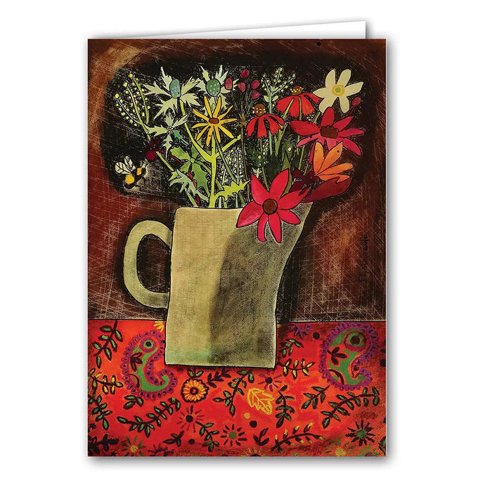 a greeting card with a colour illustration of a pitcher holding multiple wildflowers with  a bee buzzing about on a paisley tablecloth 