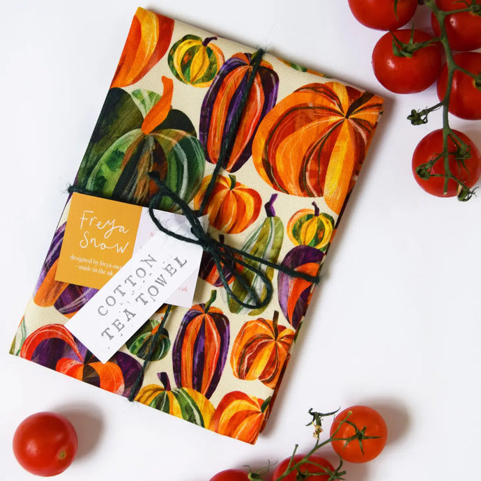 a tea towel with colourful pictures of pumpkins 