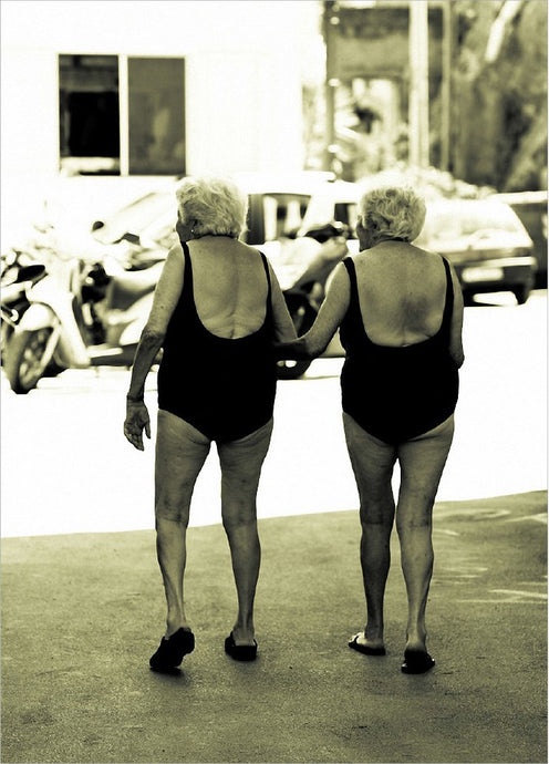 a greeting card with a black and white photo of two elderly women in black bathing suits crossing an intersection.