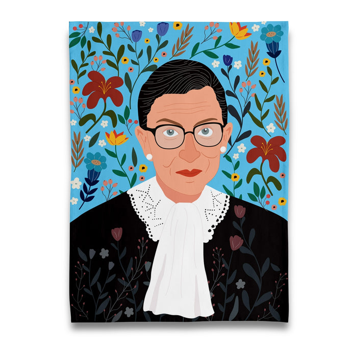 a colour tea towel or dish towel with a modern image of justice ruth bader ginsburg of the USA supreme court with a floral background she is wearing her famous black robe with lace collar