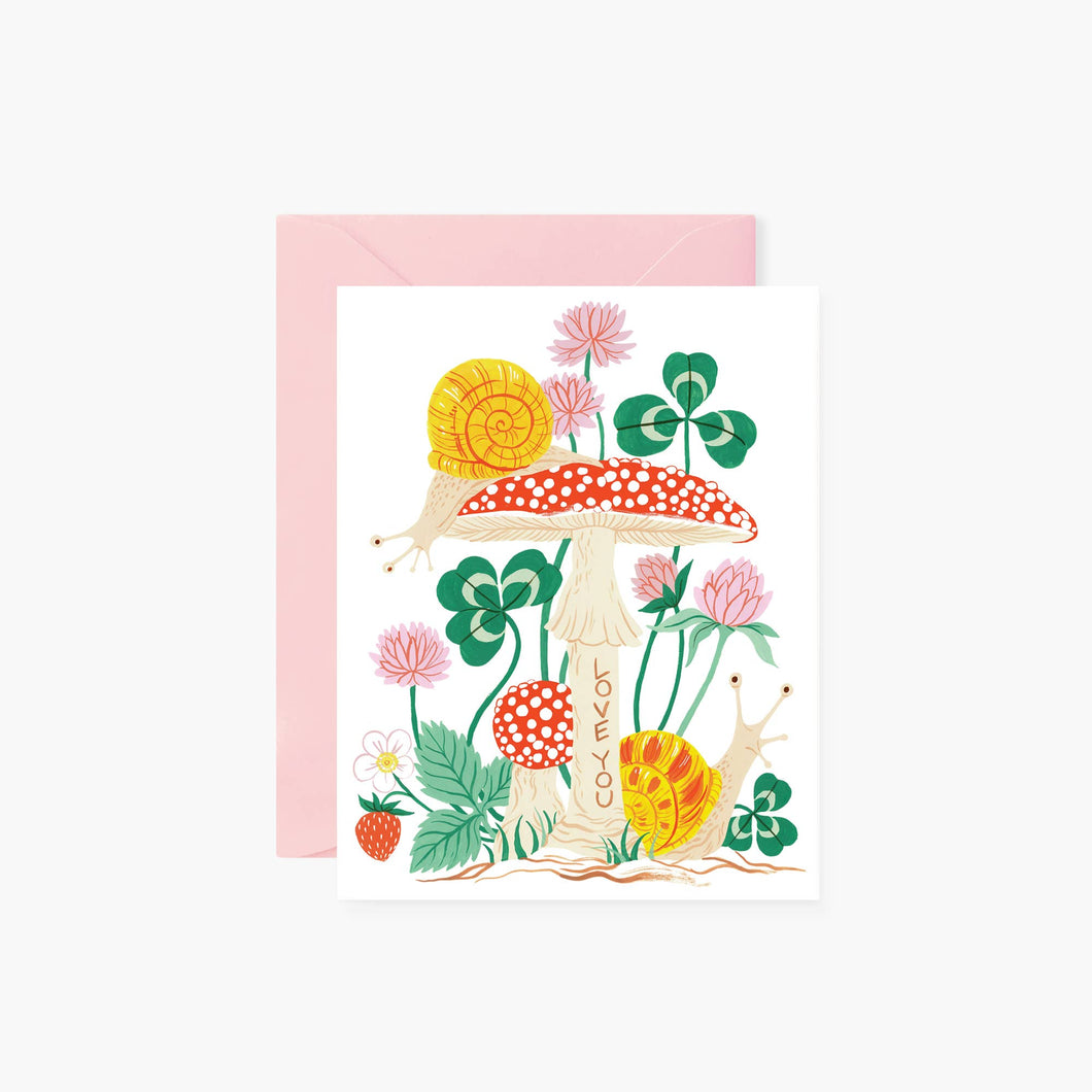 an illustration of red and white toad stools green clover strawberry snails and pink flowers very whimsical on a white back drop with soft pink envelope script on stem of toad stool love you in brown lettering  