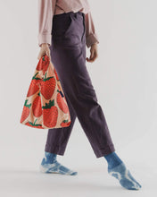 画像をギャラリービューアに読み込む, colour photo of a woman carrying a large baggu reusable bag with big red strawberries , bag is a soft muted peach colour
