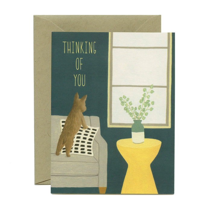 colour illustration of a little dog standing on a sofa looking out the window with text thinking of you