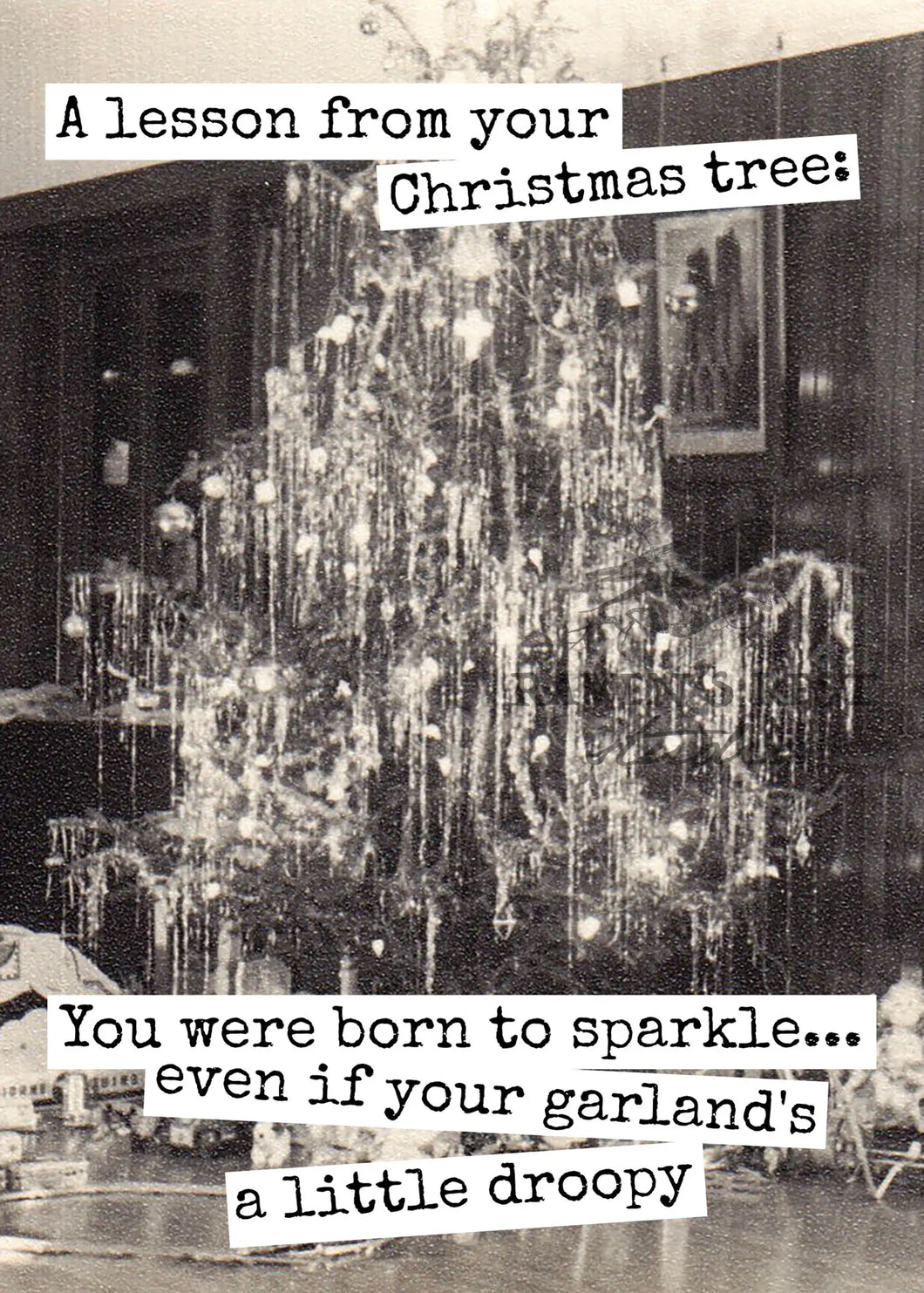 black and white photo of vintage christmas tree covered in tons of garland and tinsel 